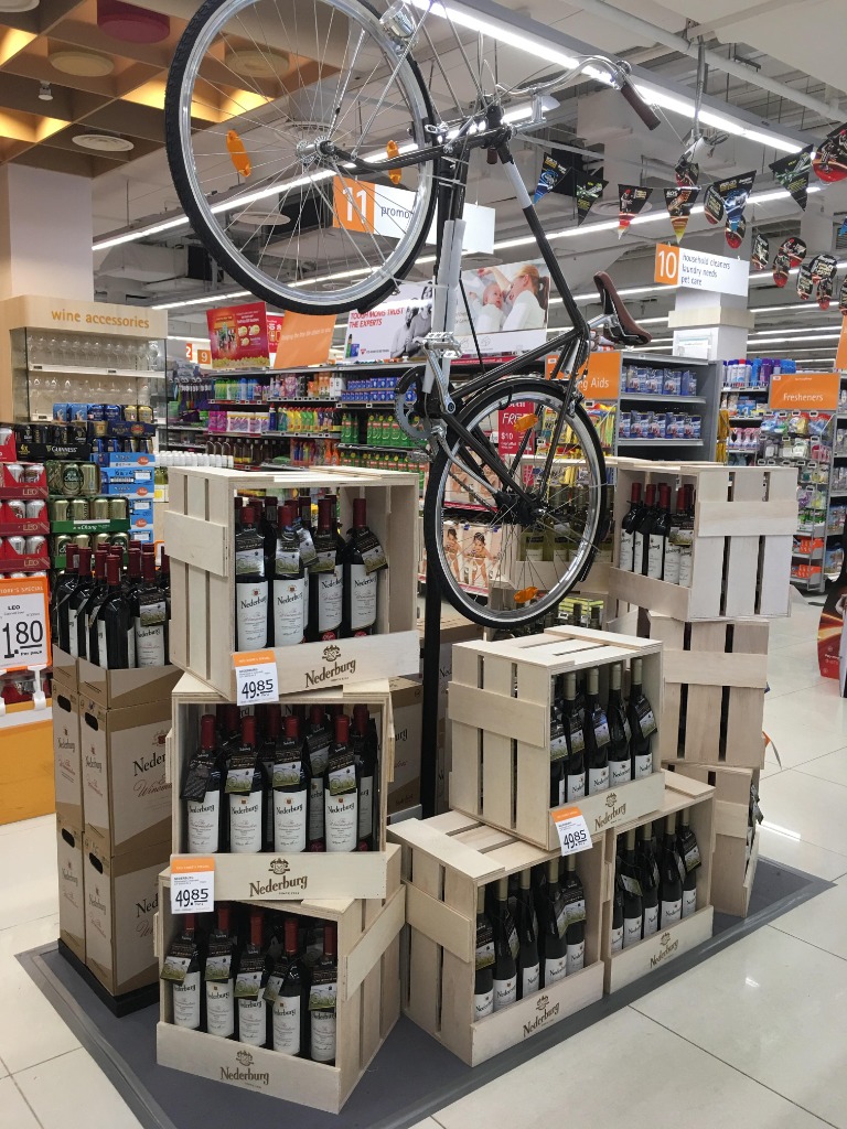 Retail brand display with custom wooden wine crates and bicycle installation - REVO Corporate Branding Singapore